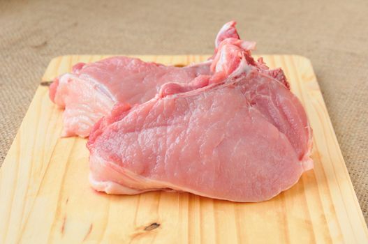 pieces of steak on the bone lying on a wooden board