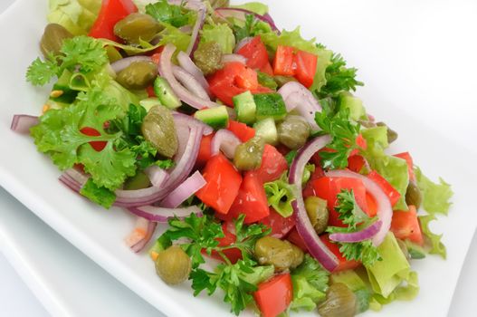 Vegetable salad with capers and herbs close