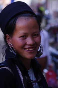 Black Hmong young women in the region of SAPA (North Vietnam). Hmong women still wear a dress. The Black Hmong women are dressed all in black. Dress, jacket and turban are black. It carries the traditional silver jewelry, earrings and necklace.