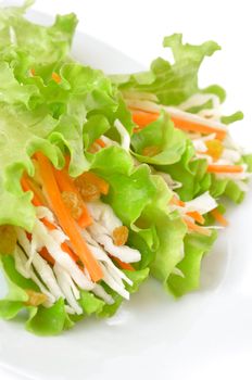 Salad with cabbage, carrots and raisins in a dish closeup