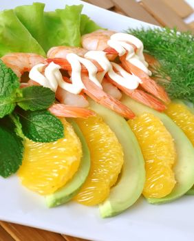 Appetizer of avocado and orange and shrimp with cream sauce