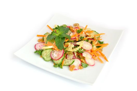 A salad of carrot, radish, cucumber, raisins, sesame and herbs

