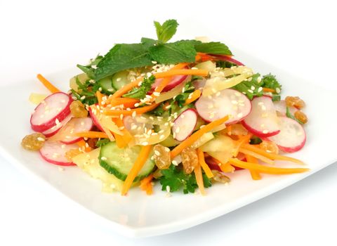 A salad of carrot, radish, cucumber, raisins, sesame and herbs