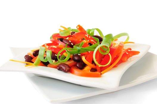 A salad of tomatoes, sweet peppers, red beans, carrots with sesame