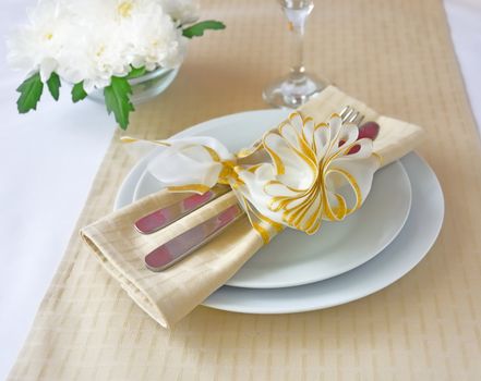 Coordinated decorative napkin on a plate with cutlery