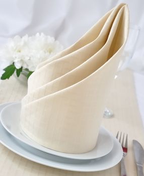 Coordinated decorative napkin on a plate with cutlery