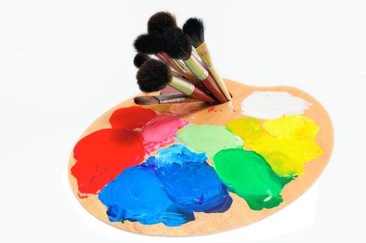 Artist palette and paintbrushes on the white background