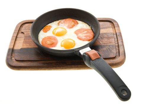 Fried eggs with tomatoes just cooked in a pan