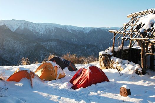 Scenery of tents at a camp on the top of mountains in winter