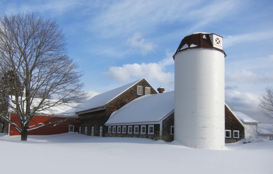 Barn with silo covered in snow during New England winter