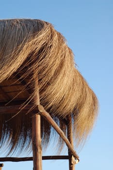 straw hut on blue sky - summer time background