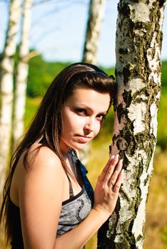 Young happy woman and birch. Shoot on the nature.