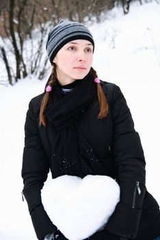 portrait of lovely young woman with heart of snow