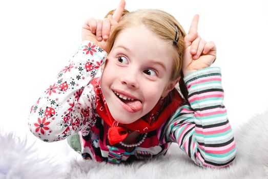 studio shot of pretty little girl with fingers like horns