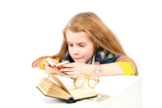 studio shot of pretty little girl reading a book