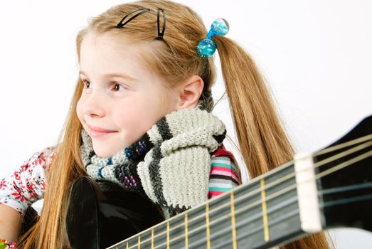 studio shot of pretty little girl playing black acoustic guitar