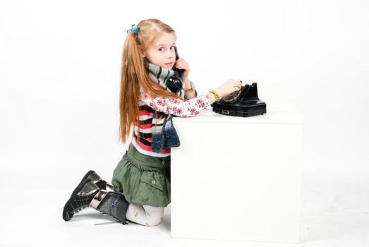 studio shot of pretty little girl calling the old phone