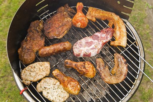 Sausages, beef and other meat on a barbecue