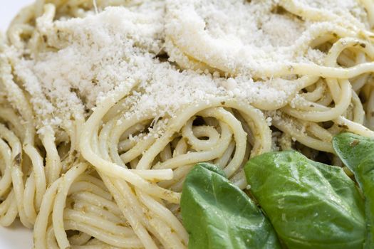 Gourmet pesto pasta dinner with fresh basil leaves.