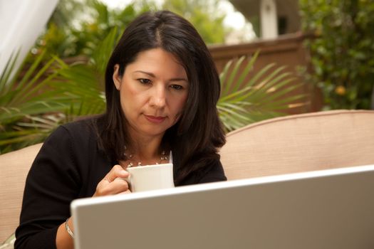 Hispanic Woman with Coffee and Laptop On Her Patio.