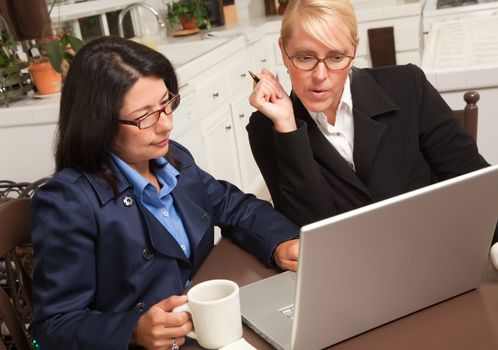 Businesswomen Working on the Laptop Together in the Kitchen.