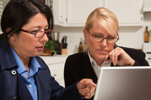 Businesswomen Working on the Laptop Together in the Kitchen.