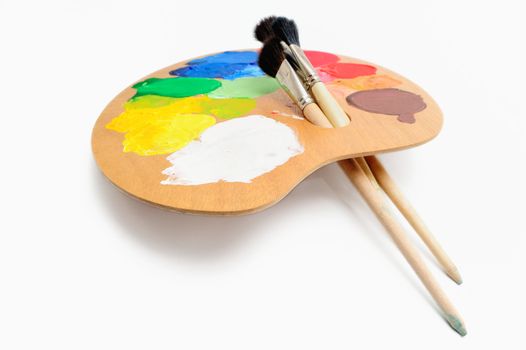 Paintbrushes on the palette with bright acrylic color