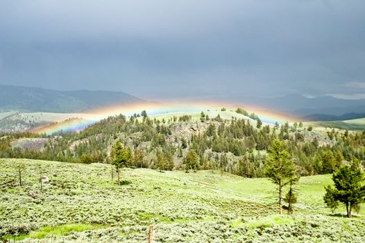 Sky lights up with rainbow after summer storm Yellowstone Park USA