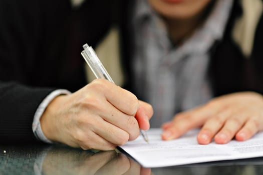 Hand with Pen Signing Form
