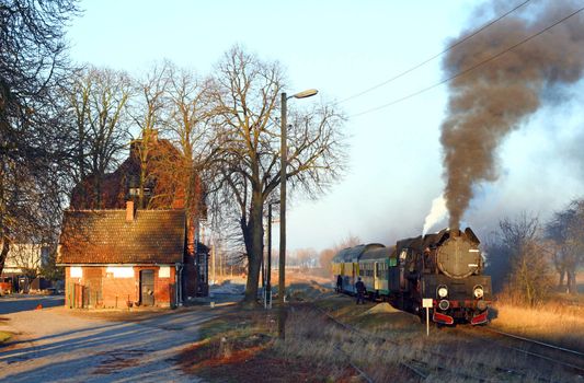 Old retro steam train stopped at the small station
