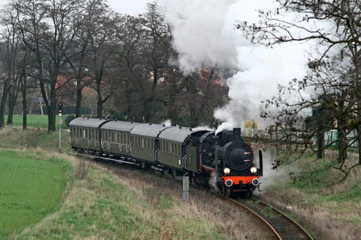 Old retro steam train passing the village