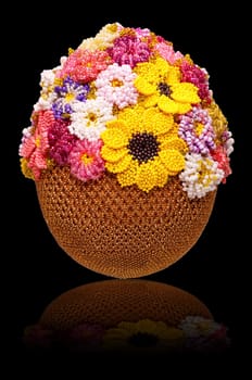 Egg decorated with beads on black background with reflection