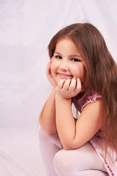 A little girl sits pensively.