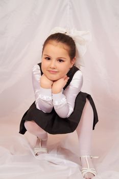 A little girl sits pensively.