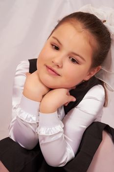 A little girl sits pensively.