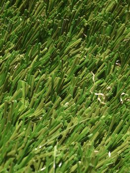 Detail of green grass artificial lawn meadow, useful as a background