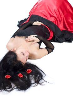 Beautiful Gothic Girl wearing black and red dress lying on the floor isolated on white