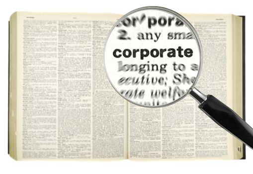 A magnifying glass on the word CORPORATE on a dictionary. Isolated on white.