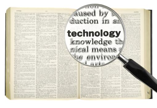 A magnifying glass on the word TECHNOLOGY on a dictionary. Isolated on white.