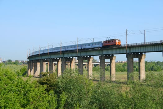 Intercity train hauled by the electric locomotive passing the estacade