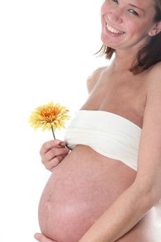Happy, pregnant woman from the side shot with flower in hand
