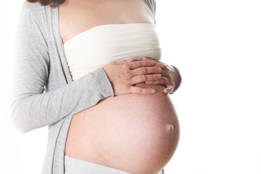 baby stomach of a pregnant woman. Only the abdomen is visible, the hands of the woman lying on her stomach protectively

