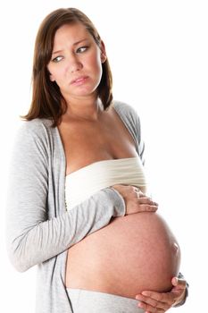 pregnant woman suffers and has complaints. She looks unhappy to the side and holding her belly
 