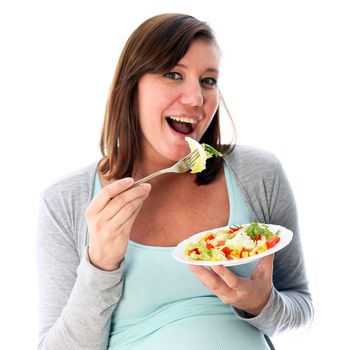 Young woman eating salad delicious and smiles. It carries out the fork to mouth
 