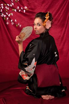 Japanese girl in traditional clothes posing to the camera