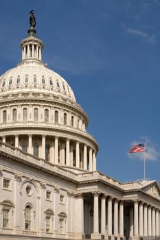 vertical photo of The Capitol, Washington DC, american flag waving, blue sky