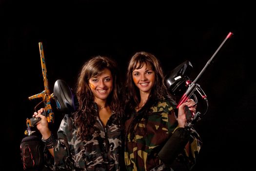 Image of a two armed paintball players posing to the camera