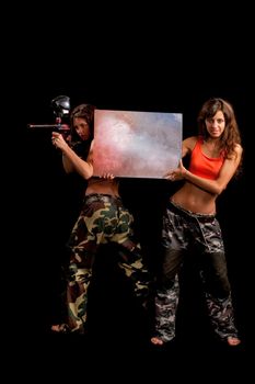 Two girls posing for camera and one holds a table like she advertise something