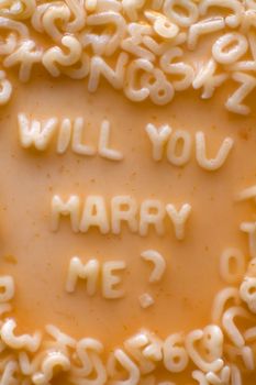 Will you marry me text made of pasta letters, ketchup tomato soup