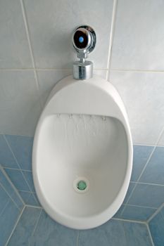 pissoir detail photo, running water, blue and white tiles on wall